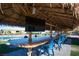 Underneath the Tiki Bar featuring ample seating and a TV, perfect for entertaining guests by the pool at 120 Chartan Ave, Las Vegas, NV 89183