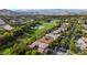 A scenic aerial view showcases an estate located on a lush green golf course with mountain views at 12097 Oakland Hills Dr, Las Vegas, NV 89141