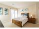 Inviting bedroom with lots of natural light, neutral paint, a wooden bed frame and plush carpeting at 12097 Oakland Hills Dr, Las Vegas, NV 89141