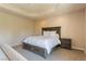 Comfortable bedroom features plush carpeting, a tray ceiling, a wooden bed frame and neutral paint at 12097 Oakland Hills Dr, Las Vegas, NV 89141