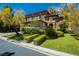 Beautiful stone home boasts an eye-catching exterior, well-manicured lawn and lush landscaping at 12097 Oakland Hills Dr, Las Vegas, NV 89141