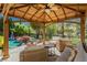 Relaxing covered patio area with comfortable seating, overlooking the pool and lush backyard at 12097 Oakland Hills Dr, Las Vegas, NV 89141