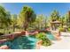 Backyard pool with relaxing hot tub and cabana surrounded by lush landscaping and mature trees at 12097 Oakland Hills Dr, Las Vegas, NV 89141