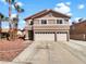 Two-story home with a red tile roof, two car garage and mature landscaping at 132 Montclair Dr, Henderson, NV 89074