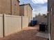 Fenced backyard featuring gravel landscaping, trash receptacles, and AC units at 1820 Peridot Point St, Las Vegas, NV 89106