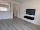 Living room with light vinyl floors and a modern wall-mounted television console at 1820 Peridot Point St, Las Vegas, NV 89106