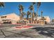 A landscaped view of Pecos Creek Condominiums featuring mature palm trees and covered parking at 1830 N Pecos Rd # 137, Las Vegas, NV 89115