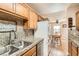 Galley kitchen featuring oak cabinets, granite countertops and stainless steel appliances at 209 Crosswind Way, Las Vegas, NV 89145