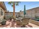 Relaxing patio with a fire pit, seating, lush landscaping, and a palm tree at 209 Crosswind Way, Las Vegas, NV 89145