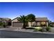 Charming single-story home features a two-car garage, desert landscaping and warm exterior lighting at 2606 Crested Butte St, Henderson, NV 89052