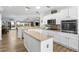 Kitchen with island, stainless appliances, granite counters, and view into dining & living areas at 2606 Crested Butte St, Henderson, NV 89052