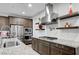 Modern kitchen featuring stainless steel appliances, granite countertops, and a stylish range hood at 2669 Via Monet, Henderson, NV 89044