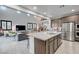 Open-concept kitchen with stainless appliances, granite island, and seamless flow to living and dining areas at 2669 Via Monet, Henderson, NV 89044