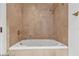 A tiled bathroom featuring a deep soaking tub with gold fixtures and neutral tile surround at 2877 Paradise Rd # 2704, Las Vegas, NV 89109