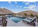 Relaxing backyard with a sparkling pool, comfortable lounge chairs, and beautiful mountain views at 3000 Raywood Ash Dr, Las Vegas, NV 89138