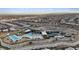 Aerial view of a community featuring a pool, clubhouse, tennis courts, and desert landscaping with mountain views at 3000 Raywood Ash Dr, Las Vegas, NV 89138