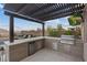 Modern outdoor kitchen with a grill, mini fridge, countertop space, and mounted TV at 3000 Raywood Ash Dr, Las Vegas, NV 89138
