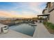 Serene backyard pool with lounge chairs, an outdoor kitchen, and mountain views at 3000 Raywood Ash Dr, Las Vegas, NV 89138