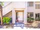 Inviting entryway with a white front door, complemented by a small bush and stairs leading to the upper level at 3123 Key Largo Dr # 101, Las Vegas, NV 89120