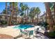 Community pool with chairs and tables, surrounded by lush palm trees for a resort-like experience at 3123 Key Largo Dr # 101, Las Vegas, NV 89120