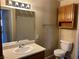 Cozy bathroom featuring a toilet, sink and vanity, mirror, and overhead storage cabinet at 340 Manti Pl # 0, Henderson, NV 89014