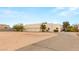Beige home with three garage doors, front door and desert landscape at 3910 W Pebble Rd, Las Vegas, NV 89139