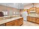 Open kitchen with wooden cabinets, tile floors, and peninsula for seating at 3910 W Pebble Rd, Las Vegas, NV 89139