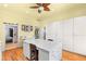 Bright laundry room features a center island and ample storage with white cabinets and yellow walls at 3910 W Pebble Rd, Las Vegas, NV 89139