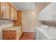 Laundry room with custom wood cabinets, folding counter, and white washer and dryer units at 3910 W Pebble Rd, Las Vegas, NV 89139