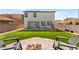 Spacious backyard featuring a well-maintained lawn, comfortable chairs, and a fire pit at 4352 Browns Creek Ave, North Las Vegas, NV 89084