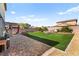 Large backyard with artificial grass, fire pit, planter boxes, and a brick patio for gatherings at 4352 Browns Creek Ave, North Las Vegas, NV 89084