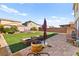 Large backyard with artificial grass, a seating area with a fire pit, and planter boxes at 4352 Browns Creek Ave, North Las Vegas, NV 89084