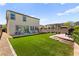 Green backyard with artificial turf, seating area, a fire pit, and easy access to indoor areas at 4352 Browns Creek Ave, North Las Vegas, NV 89084