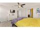 Bright bedroom featuring a ceiling fan, TV, and a yellow and purple bedspread at 4352 Browns Creek Ave, North Las Vegas, NV 89084