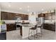 A modern kitchen with a center island, dark wood cabinets, stainless steel appliances, and granite countertops at 4352 Browns Creek Ave, North Las Vegas, NV 89084