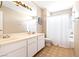 Bright bathroom features a double sink vanity, full bathtub with shower, and decorative flooring at 4360 Flandes St, Las Vegas, NV 89121