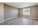 Bedroom with wood-look flooring, neutral walls, a bright window, and white trim at 4516 Townwall St, Las Vegas, NV 89115