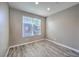 Cozy bedroom featuring natural light from window and complementing gray wood-look flooring at 4516 Townwall St, Las Vegas, NV 89115