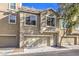 Exterior townhome featuring two-car garage, neutral paint and tidy landscaping at 4516 Townwall St, Las Vegas, NV 89115