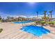 Community pool with sundeck, lounge chairs and lush landscaping under a beautiful sky at 4516 Townwall St, Las Vegas, NV 89115
