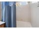 Bathroom with a bathtub featuring tiled walls and a blue textured curtain at 4631 Forest Shadow Ave, Las Vegas, NV 89139