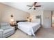 Inviting bedroom featuring a cozy armchair, stylish lamps, and soft carpeting at 4631 Forest Shadow Ave, Las Vegas, NV 89139