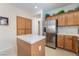 Spacious kitchen area with a stainless steel refrigerator, tile counters, and wooden cabinets at 4631 Forest Shadow Ave, Las Vegas, NV 89139