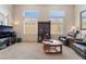 Bright and airy living space with tall windows and neutral carpeting, furnished with a comfortable seating arrangement at 4631 Forest Shadow Ave, Las Vegas, NV 89139