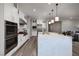 Modern kitchen with stainless steel appliances, double ovens, quartz countertops, and a large center island at 47 Reflection Bay Dr, Henderson, NV 89011