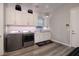 Well-organized laundry room featuring a sink, washer, dryer and plenty of storage at 47 Reflection Bay Dr, Henderson, NV 89011