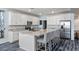Bright kitchen features white cabinetry, stainless appliances, and granite countertops with an island and barstool seating at 4801 Westmont Dr, Pahrump, NV 89061