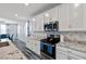 Bright kitchen boasts white cabinets, stainless steel microwave, and granite countertops, for culinary excellence at 4801 Westmont Dr, Pahrump, NV 89061