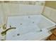 Jetted bathtub in a tiled bathroom setting, featuring gold-toned fixtures at 5010 Longboat Cir, Las Vegas, NV 89113