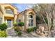 Inviting home exterior boasts beautiful stone landscaping, a water feature, and a charming, covered entryway at 5010 Longboat Cir, Las Vegas, NV 89113